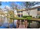 Scenic view of condo exterior overlooking a pond with a wooden dock, blending nature with residential living at 4160 Pinelake Ln # 201, Tampa, FL 33618