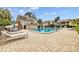 Community pool with lounge chairs, table, and brick paver deck at 4160 Pinelake Ln # 201, Tampa, FL 33618
