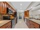 Galley kitchen boasts stainless steel appliances, tile floors, warm wood cabinetry, and stone countertops at 4160 Pinelake Ln # 201, Tampa, FL 33618