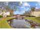 Tranquil pond view of condos with a wooden bridge, surrounded by lush landscaping creating a peaceful community setting at 4160 Pinelake Ln # 201, Tampa, FL 33618