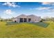Expansive backyard featuring lush green grass, a screened-in lanai, and views of the surrounding landscape at 4315 70Th E Ave, Ellenton, FL 34222