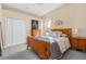 Comfortable bedroom with a wooden bed frame, dresser, and carpeted floor at 4315 70Th E Ave, Ellenton, FL 34222