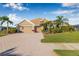 Lovely single-story home featuring a three-car garage, brick driveway, and mature palm trees at 4315 70Th E Ave, Ellenton, FL 34222