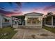 Charming single-story home featuring a cozy covered porch and neat landscaping at sunset at 647 Yawl Ln, Palm Harbor, FL 34683