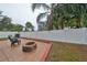 Spacious fenced backyard with a concrete patio and fire pit area at 6930 Summer Harbor Ln, Riverview, FL 33578