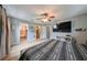 Bright main bedroom boasts an ensuite bathroom, walk-in closet, ceiling fan, and mounted TV at 6930 Summer Harbor Ln, Riverview, FL 33578