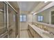 Bright bathroom with a glass-enclosed shower and double sink vanity with large mirror at 727 Flamingo Dr, Apollo Beach, FL 33572