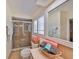 Well lit bathroom featuring a glass-enclosed shower, tiled floors, and shuttered windows at 727 Flamingo Dr, Apollo Beach, FL 33572