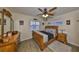 Comfortable bedroom featuring plantation shutters, wood floors, and a ceiling fan at 727 Flamingo Dr, Apollo Beach, FL 33572
