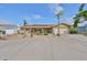 Charming single-story home featuring a two-car garage, a circular driveway, and palm trees in the front yard at 727 Flamingo Dr, Apollo Beach, FL 33572
