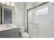 Modern bathroom featuring white tile, a glass shower, gray vanity, and contemporary fixtures at 8521 Dove Bog Ter, Parrish, FL 34219
