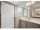 Bathroom features a walk-in glass shower, gray vanity with double sinks, and a window for natural light at 8521 Dove Bog Ter, Parrish, FL 34219