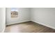 Bedroom features warm wood flooring, natural light from the window, and neutral walls at 8521 Dove Bog Ter, Parrish, FL 34219