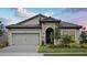 Charming single-story home featuring a stone facade, two-car garage, and well-manicured landscaping at 8521 Dove Bog Ter, Parrish, FL 34219