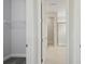 Bright hallway view showcasing neutral walls, and an inviting bathroom featuring a glass-enclosed shower at 8521 Dove Bog Ter, Parrish, FL 34219