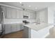 Stylish kitchen boasts gray cabinetry, stainless steel appliances, a center island, and quartz countertops at 8521 Dove Bog Ter, Parrish, FL 34219