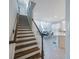 Bright staircase with wooden steps, white railings, leads into living and dining areas at 8890 Arabella Ln, Seminole, FL 33777