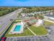 Aerial view of community pool, tennis court, and well-manicured lawns near a busy street at 9115 Tudor Dr # E109, Tampa, FL 33615