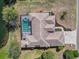 Overhead view of the property highlighting the roof, screened-in pool area, and surrounding landscape at 10084 Twelve Oaks Ct, Weeki Wachee, FL 34613
