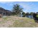 Expansive backyard view with lush grass and a tranquil lake, offering a serene and picturesque setting at 10084 Twelve Oaks Ct, Weeki Wachee, FL 34613