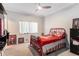 Bedroom features a red bed, neutral walls, and a ceiling fan at 10084 Twelve Oaks Ct, Weeki Wachee, FL 34613