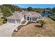 Exterior view of a single Gathering home with a tile roof, columns, and a three car garage at 10084 Twelve Oaks Ct, Weeki Wachee, FL 34613