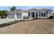 Exterior view of a single Gathering home with a tile roof, columns, and a three car garage at 10084 Twelve Oaks Ct, Weeki Wachee, FL 34613