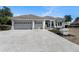 Exterior view of a single Gathering home with a tile roof, columns, and a three car garage at 10084 Twelve Oaks Ct, Weeki Wachee, FL 34613