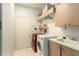 Clean laundry room featuring a washer, dryer, sink and storage space at 10084 Twelve Oaks Ct, Weeki Wachee, FL 34613