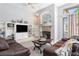 Comfortable living room with a stone fireplace, plush leather sofas, and built-in shelving at 10084 Twelve Oaks Ct, Weeki Wachee, FL 34613