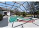 Screened-in pool and spa overlook a scenic backyard with water views at 10084 Twelve Oaks Ct, Weeki Wachee, FL 34613