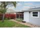 Backyard with a screened-in sunroom, red fence, and well-maintained lawn at 1016 Greenleaf Way, Tarpon Springs, FL 34689