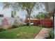 Cozy backyard featuring a small lawn, brick-accented wall, and mature landscaping at 1016 Greenleaf Way, Tarpon Springs, FL 34689