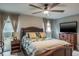 Comfortable bedroom featuring a ceiling fan, TV, and bedside table with a lamp at 1016 Greenleaf Way, Tarpon Springs, FL 34689