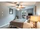 Bedroom with a cozy chair, dresser, ceiling fan, and neutral color scheme at 1016 Greenleaf Way, Tarpon Springs, FL 34689