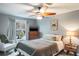 Bright bedroom with ceiling fan, dresser, and view of flowering trees outside the window at 1016 Greenleaf Way, Tarpon Springs, FL 34689