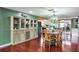 Charming dining area with hardwood floors, stylish cabinet, and access to the kitchen at 1016 Greenleaf Way, Tarpon Springs, FL 34689