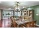 Bright dining room featuring wood floors, green accent wall, and stylish light fixture at 1016 Greenleaf Way, Tarpon Springs, FL 34689