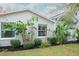 Lush landscaping featuring banana trees and well-maintained greenery surrounding the home's exterior at 1016 Greenleaf Way, Tarpon Springs, FL 34689