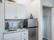 Kitchenette featuring white cabinets, granite countertop, and stainless steel mini-fridge at 1016 Greenleaf Way, Tarpon Springs, FL 34689