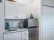 Kitchenette featuring white cabinets, granite countertop, and stainless steel mini-fridge at 1016 Greenleaf Way, Tarpon Springs, FL 34689