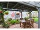 Charming patio with dining set, garden decor, and a beautiful brick surround at 1016 Greenleaf Way, Tarpon Springs, FL 34689
