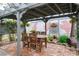 Outdoor patio with wooden table, chairs, and a charming brick-lined garden at 1016 Greenleaf Way, Tarpon Springs, FL 34689