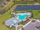 Overhead view features a community pool, clubhouse, ample parking, and a picturesque pond surrounded by green space at 10741 Charlotte Dr, Parrish, FL 34219