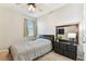 Cozy bedroom with natural light, complemented by a dresser with mirror, a ceiling fan and neutral colors at 10741 Charlotte Dr, Parrish, FL 34219
