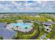 Aerial view of the community pool and amenity center featuring a splash pad, playground, and lounge area at 10741 Charlotte Dr, Parrish, FL 34219