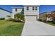 Charming two-story home featuring a manicured lawn and a two-car garage with a long concrete driveway at 10741 Charlotte Dr, Parrish, FL 34219