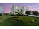 Exterior view of a well-maintained two-story home with a green lawn and landscaped surroundings at dusk at 10741 Charlotte Dr, Parrish, FL 34219