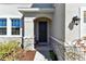 Front entrance featuring a black front door, stone accents, and manicured landscaping at 10741 Charlotte Dr, Parrish, FL 34219