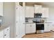 Well-equipped kitchen featuring white cabinets, granite countertops, stainless steel appliances and wood-look flooring at 10741 Charlotte Dr, Parrish, FL 34219
